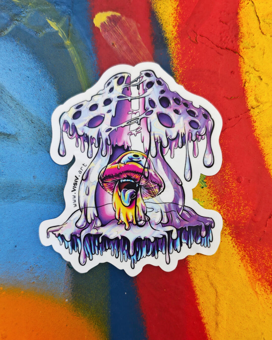 Photo of a Mushy sticker — a one-eyed purple psychedelic rave mushroom mascot with neon details.